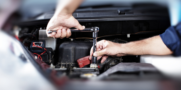 Student working on car with wrench